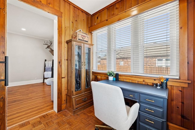 office with wood walls, baseboards, parquet floors, built in study area, and crown molding