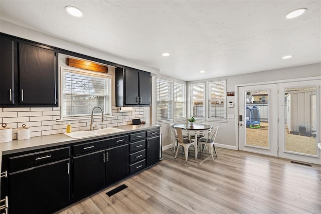 kitchen featuring dark cabinets, visible vents, and a sink