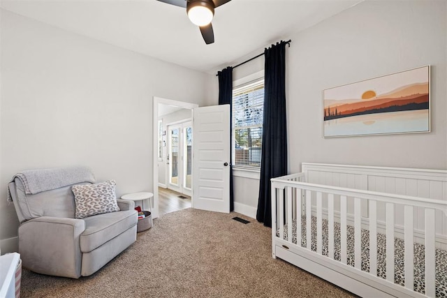 carpeted bedroom with a nursery area, ceiling fan, and visible vents