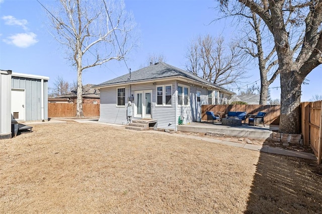 back of property with entry steps, a patio area, a fenced backyard, and roof with shingles