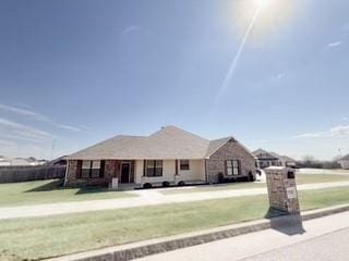 ranch-style home featuring a front lawn