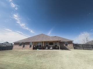 back of property with fence and a lawn