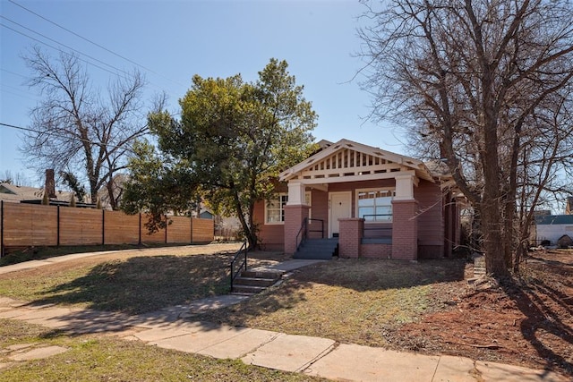 view of front of house with brick siding and fence