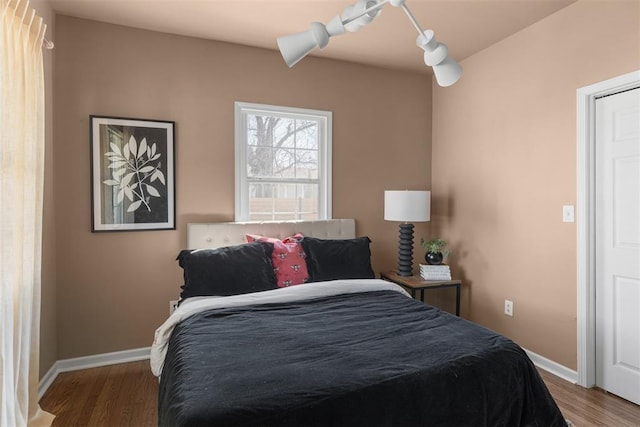 bedroom featuring wood finished floors and baseboards