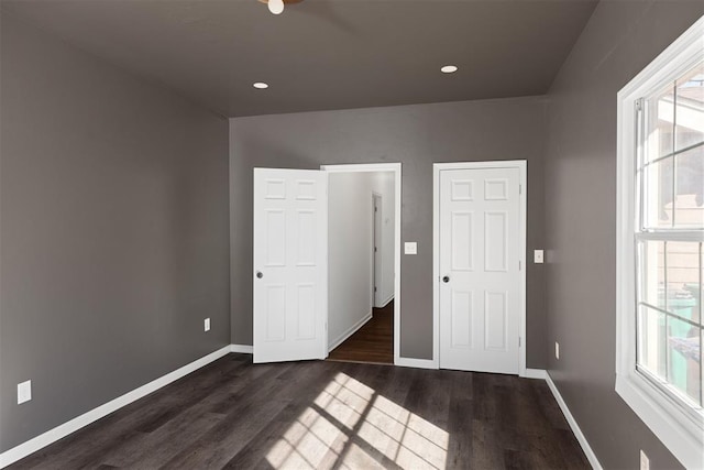 unfurnished bedroom with dark wood-type flooring, recessed lighting, and baseboards