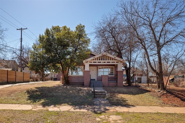 view of front facade featuring brick siding and fence