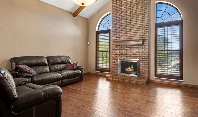 living room featuring baseboards, wood finished floors, a brick fireplace, high vaulted ceiling, and beam ceiling