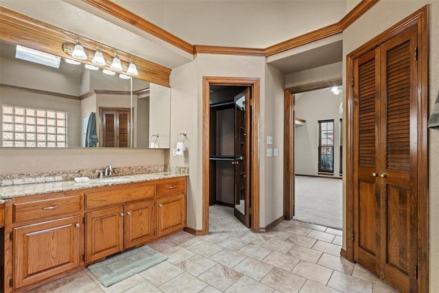 bathroom featuring baseboards, crown molding, and vanity