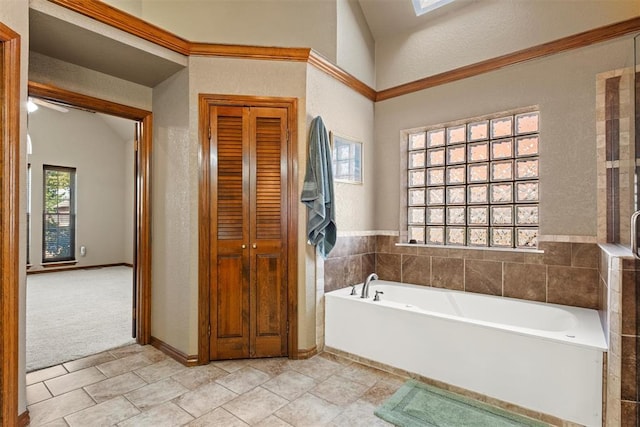 full bath with a textured wall, a closet, a garden tub, and tile patterned floors