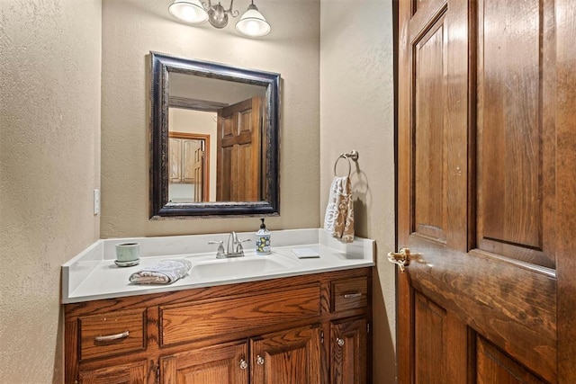 bathroom with a textured wall and vanity