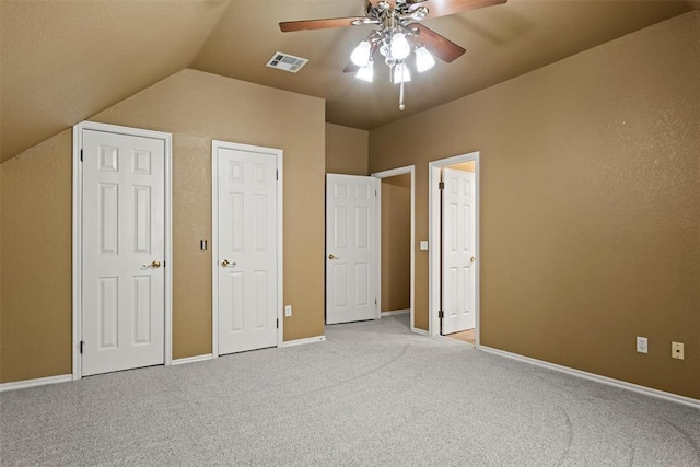 unfurnished bedroom with light carpet, baseboards, visible vents, lofted ceiling, and ceiling fan