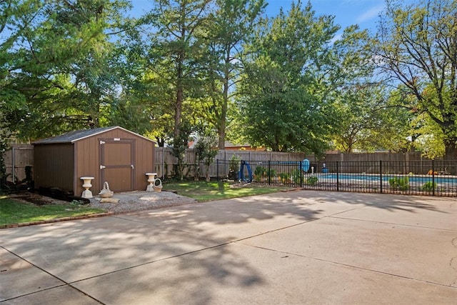 view of patio / terrace featuring a fenced in pool, an outdoor structure, a storage shed, and fence