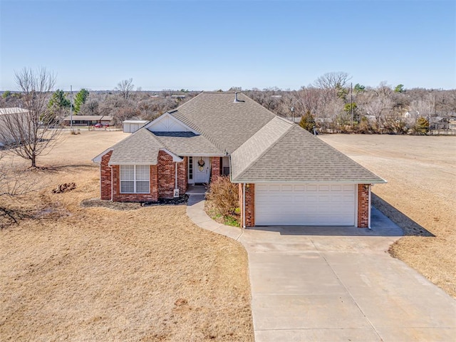 view of front of property with a garage, concrete driveway, brick siding, and roof with shingles