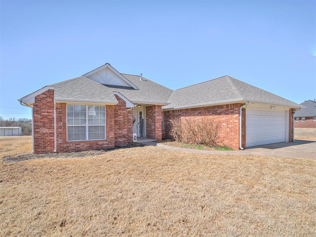 view of front of home with brick siding, a shingled roof, an attached garage, a front yard, and driveway