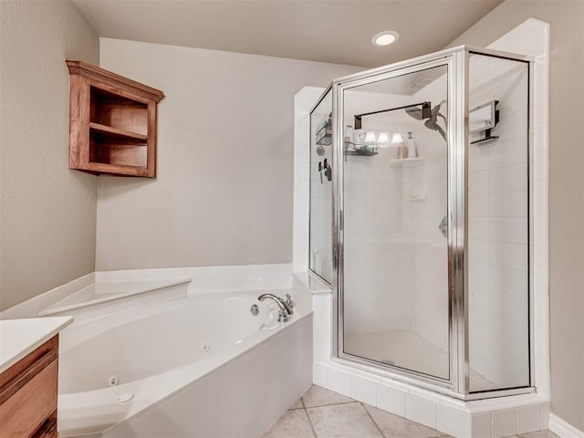 bathroom featuring a jetted tub, a shower stall, and tile patterned flooring