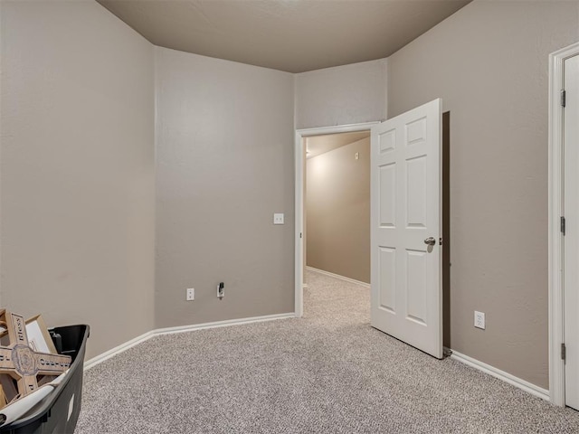 unfurnished bedroom featuring baseboards and light colored carpet