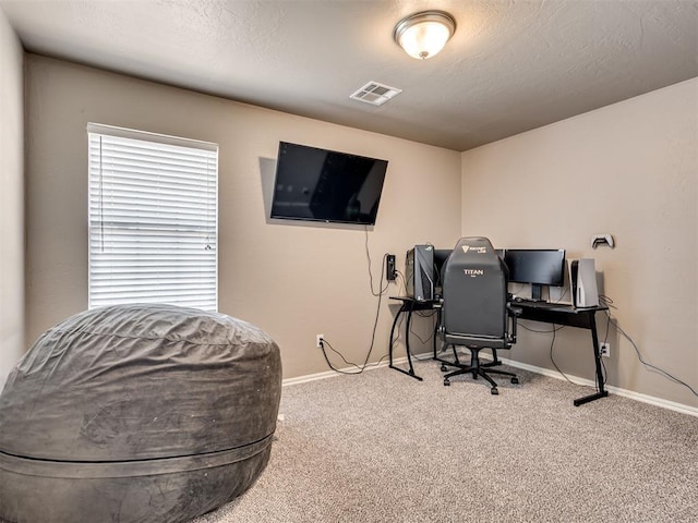 carpeted home office featuring a textured ceiling, visible vents, and baseboards