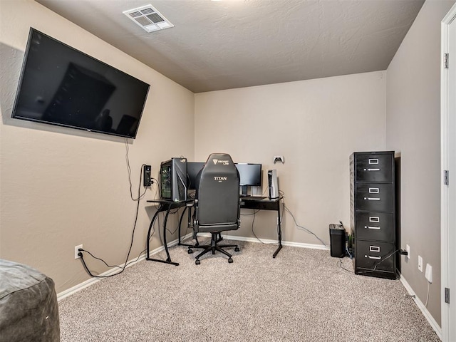 home office with a textured ceiling, carpet flooring, visible vents, and baseboards