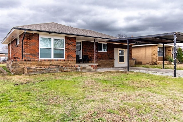 view of front of house featuring roof with shingles, brick siding, and a front lawn