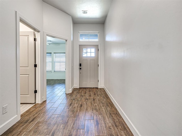 entryway with wood finished floors, visible vents, and baseboards