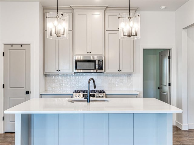 kitchen featuring stainless steel microwave, backsplash, and an inviting chandelier