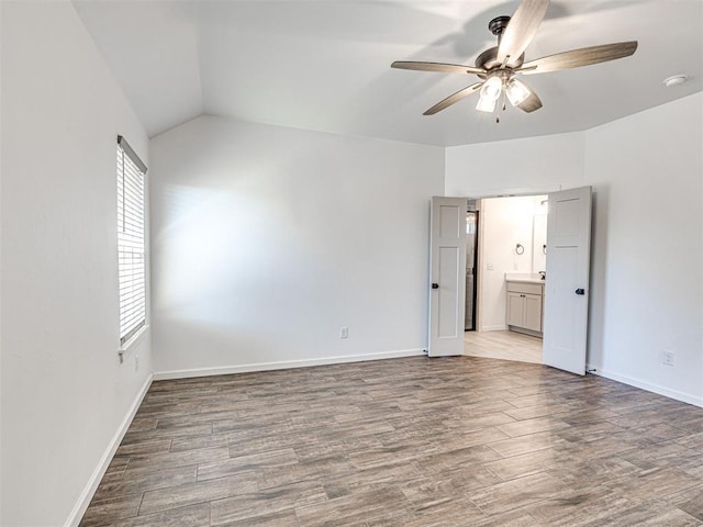 empty room with wood finished floors, a ceiling fan, and baseboards