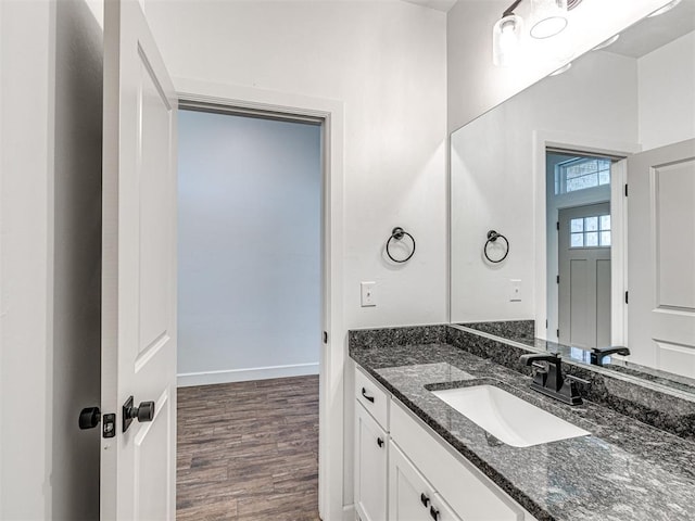 bathroom featuring wood finished floors, vanity, and baseboards