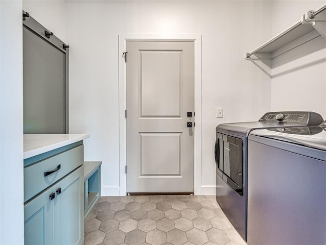 laundry area with cabinet space, independent washer and dryer, baseboards, and a barn door