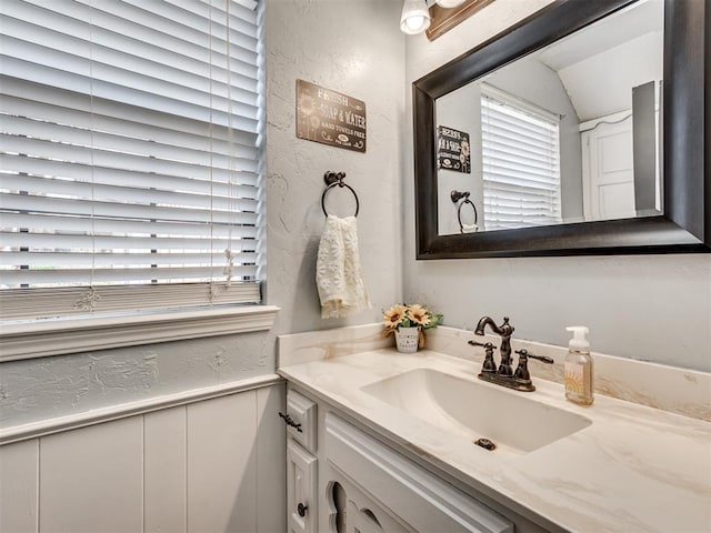 bathroom featuring a textured wall and vanity