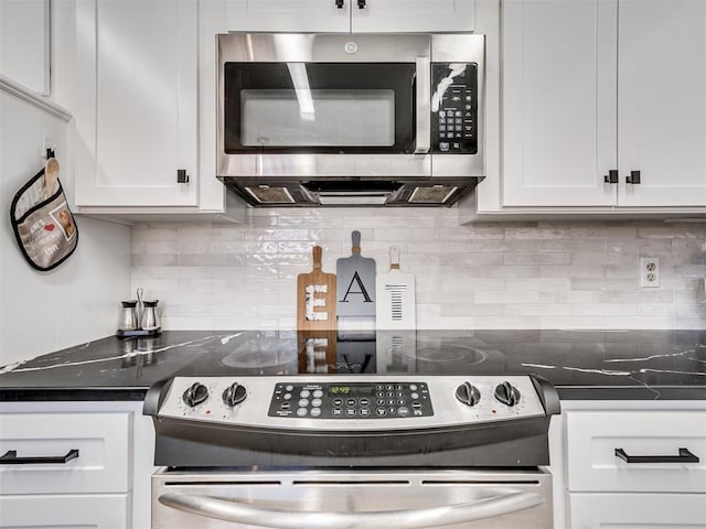 kitchen with appliances with stainless steel finishes, dark countertops, white cabinets, and tasteful backsplash