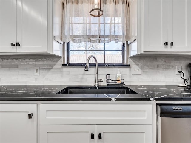 kitchen featuring backsplash, white cabinets, a sink, dark stone countertops, and dishwasher