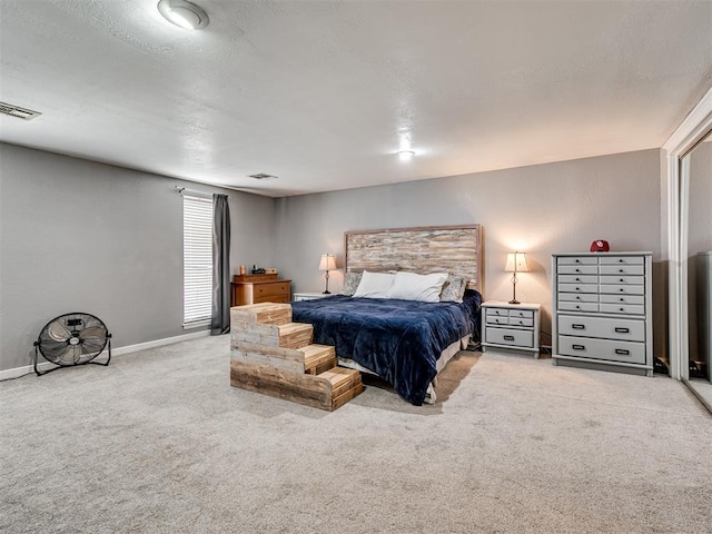 carpeted bedroom featuring baseboards, visible vents, and a textured ceiling