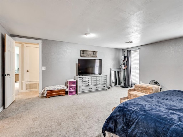 carpeted bedroom with visible vents, a textured wall, and a textured ceiling