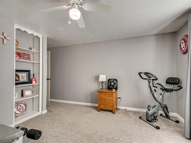 workout room with a ceiling fan, baseboards, and carpet flooring