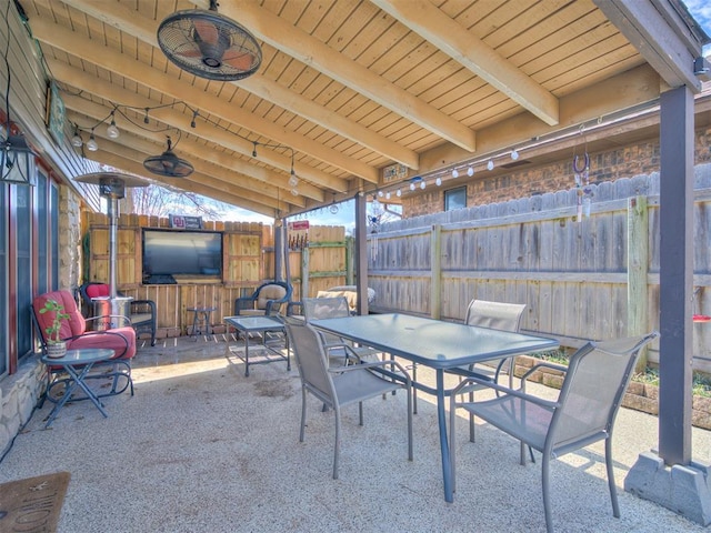 view of patio with outdoor dining area, fence, and ceiling fan