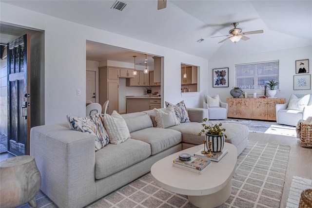 living room with lofted ceiling, light wood-style flooring, visible vents, and ceiling fan