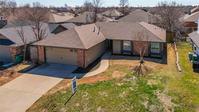 ranch-style house with a front yard, driveway, an attached garage, brick siding, and a residential view