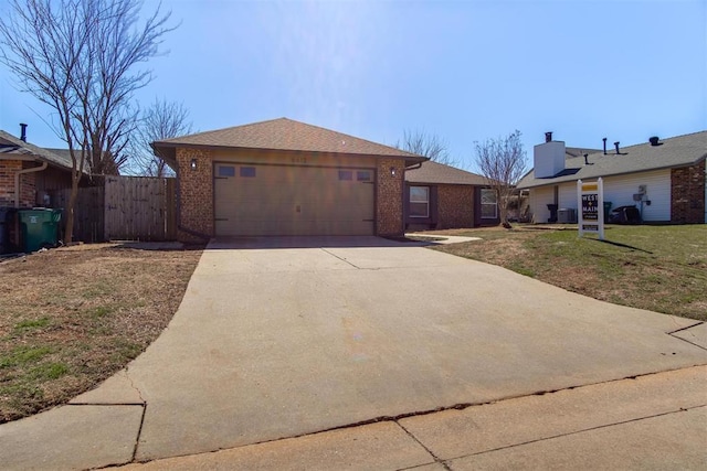 ranch-style home featuring fence, concrete driveway, a front lawn, a garage, and brick siding