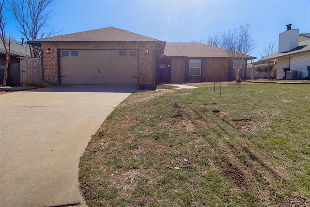 ranch-style home with brick siding, a front lawn, central AC unit, a garage, and driveway