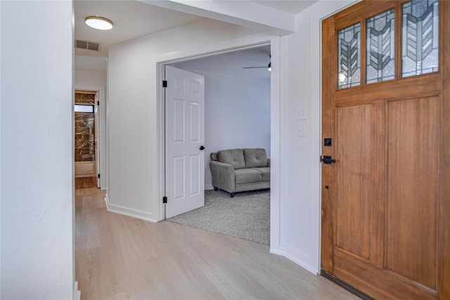 entryway featuring visible vents, baseboards, and wood finished floors