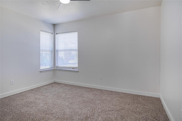 spare room featuring baseboards, light carpet, a textured ceiling, and a ceiling fan