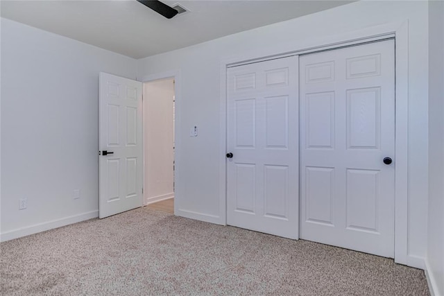 unfurnished bedroom with a closet, visible vents, baseboards, and carpet floors