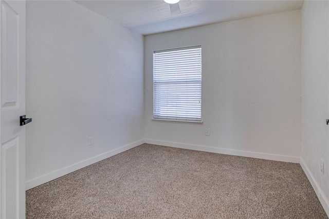 unfurnished room with light carpet and baseboards