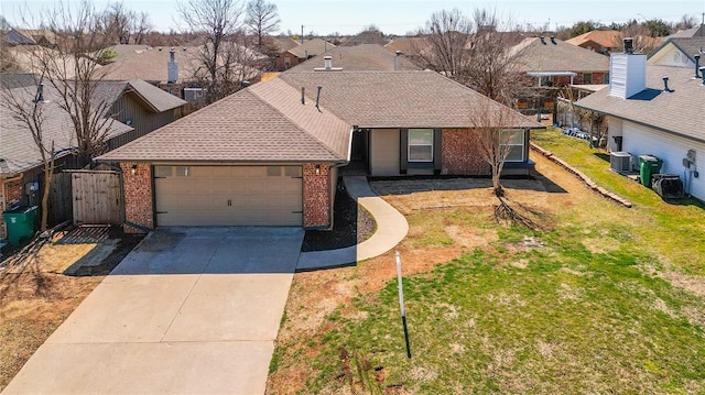 view of front facade with brick siding, a front yard, central AC unit, driveway, and an attached garage