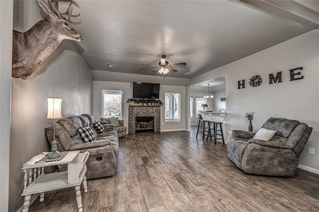 living room featuring baseboards, ceiling fan, visible vents, and wood finished floors