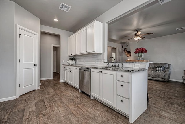 kitchen with visible vents, a sink, a peninsula, and stainless steel dishwasher