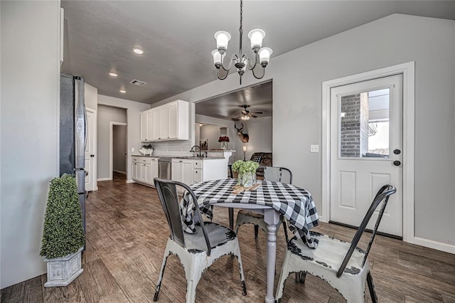 dining space with dark wood-style floors, visible vents, baseboards, and ceiling fan with notable chandelier