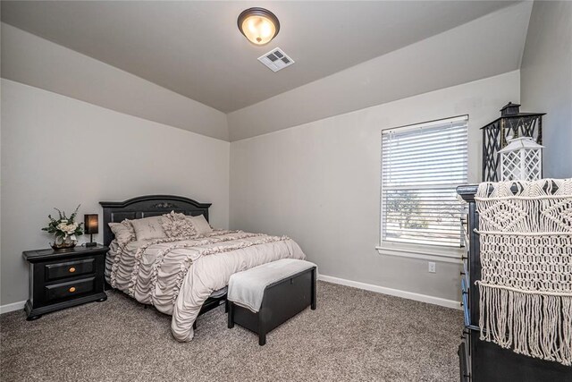 carpeted bedroom with lofted ceiling, baseboards, and visible vents