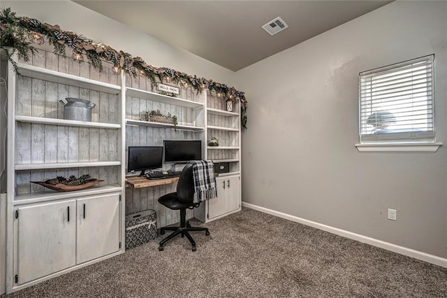 carpeted office space featuring visible vents and baseboards