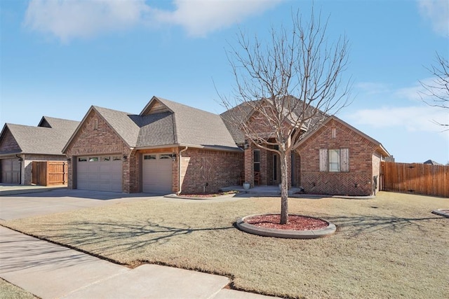 view of front facade featuring a garage, a shingled roof, concrete driveway, fence, and brick siding